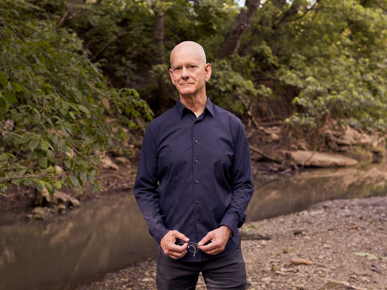 Eric Moe, standing by a creek